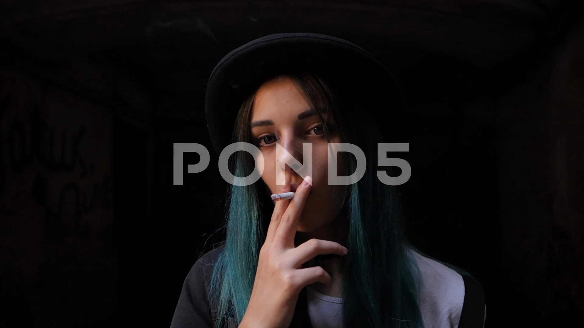 SLOW MOTION: emo girl smoking cigarette.Street punk or hipster woman with  blue