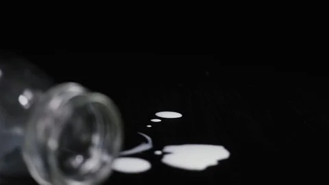 Slow motion. Empty milk bottle on a black table with drops Stock Footage 75268632