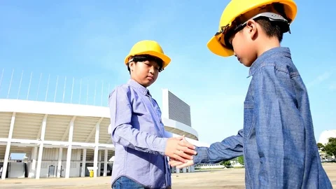 Slow motion Engineer boy wearing yellow safety helmet and shaking hand Stock Footage 76972565