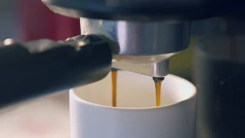 Slow motion espresso coffee pouring from machine into ceramic cup for fresh.. Stock Footage 336944554