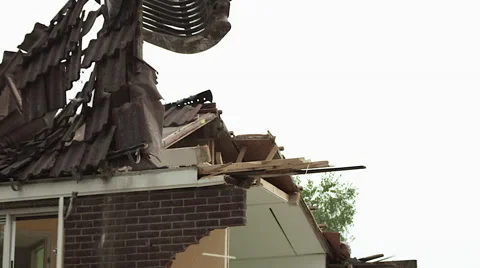 Slow motion excavator demolition crushing a house Stock Footage 57465347