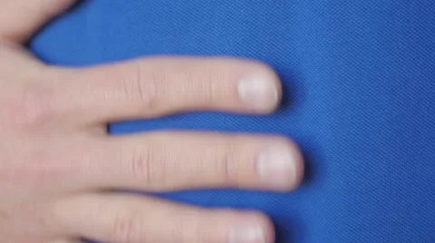 Slow motion of an extreme close up of a man hand on a blue shirt Stock Footage 49885897