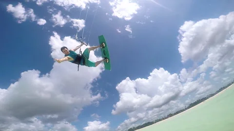 SLOW MOTION: Extreme kite surfer jumping high over camera showing thumbs up Stock Footage 66495439