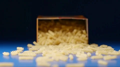 SLOW MOTION: Falling a box with a spiral pasta (fusilli) Video stock 75436991