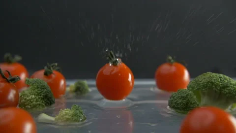 Slow motion of falling cherry tomato among broccoli Stock Footage 97884826