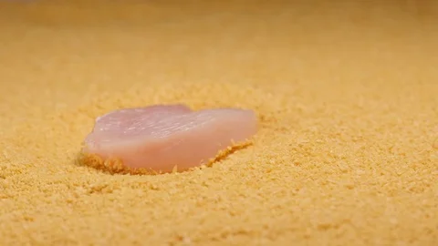 SLOW MOTION: Falling a chicken fillet in a beading powder - macro shot Stock Footage 75436812