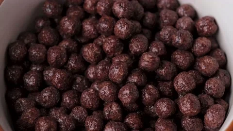 Slow motion falling chocolate cereal balls top view. Vidéo 146501553