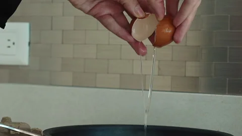 Slow motion of falling egg into frying pan, footage food Stock Footage 167804922