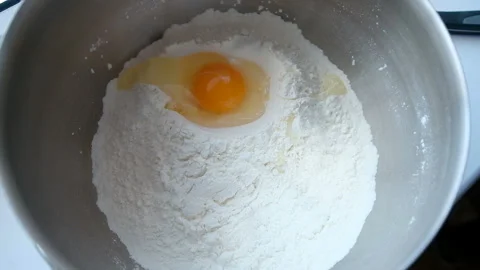 Slow motion of falling eggs into flour stock footage food Stockbeeldmateriaal 86359588