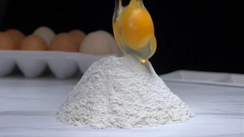 Slow motion of falling eggs in flour stock. Stock Footage 103308277