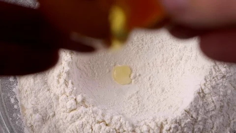 Slow motion of falling eggs into flour. Egg dropping into flour. 動画素材 122169230