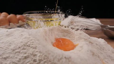 Slow motion of falling eggs into flour Video stock 181656501