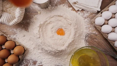 Slow motion of falling eggs into flour - top view Stock Footage 181657166