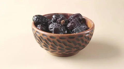 Slow motion of falling fresh date fruit in a bowl on table Video stock 179059399