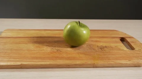 Slow motion falling green apple fruit on cooking table and bouncing close up Stock Footage 113070996