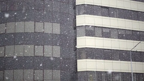 Slow Motion of Falling Snow on the background of a Modern high-rise Building Stock Footage 83026717