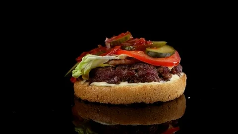 Slow motion of falling top bun on beef burger Stock Footage 77585900