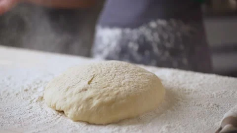 Slow motion of falling yeast dough into flour close up. Stock Footage 189234110