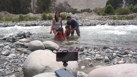 Slow motion of a family posing for a cell phone picture in the water Видео 150921719