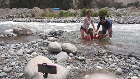 Slow motion of a family posing for a cell phone picture in the water Stock Footage 150921731