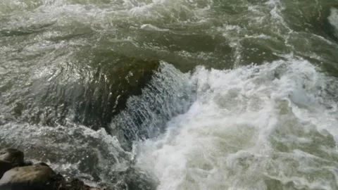 Slow motion of a fast flowing river in the rocky mountains Video stock 320977662