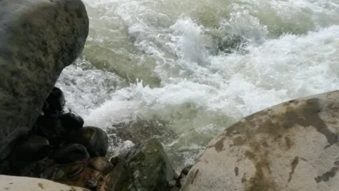 Slow motion of a fast flowing river in the rocky mountains Video stock 320977669