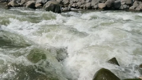 Slow motion of a fast flowing river in the rocky mountains Video stock 320977746