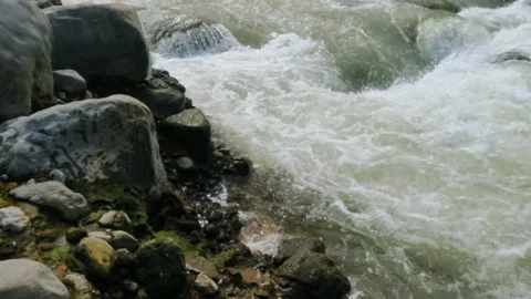 Slow motion of a fast flowing river in the rocky mountains Video stock 320977814