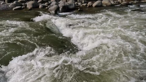 Slow motion of a fast flowing river in the rocky mountains Video stock 320977869