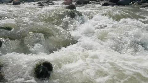 Slow motion of a fast flowing river in the rocky mountains Video stock 320977918