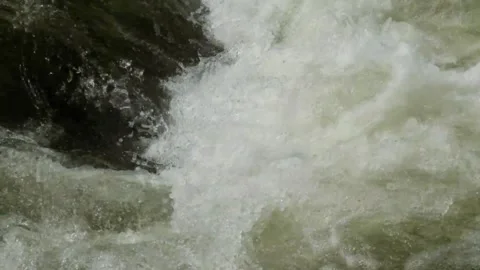 Slow motion of a fast flowing rocky mountain river Video stock 320954555
