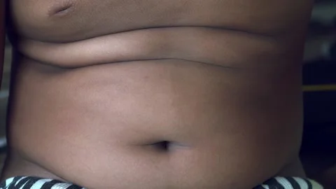 Slow motion fat boy checking belly. Video stock 158532659