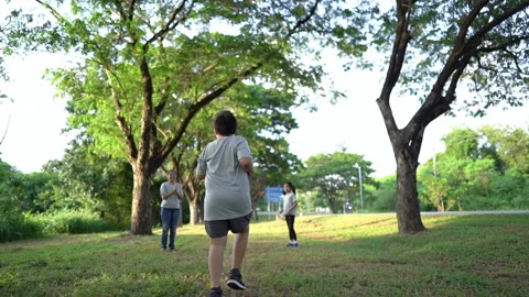 Slow motion fat boy running and family applause hands clapping in park. Stock Footage 163645379