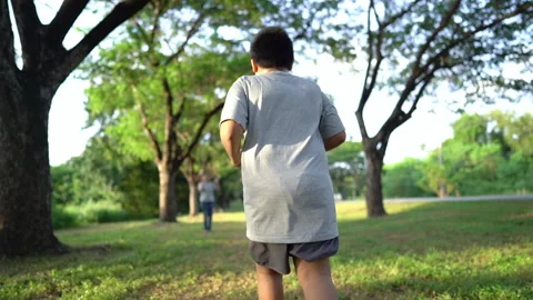 Slow motion fat boy running and family applause hands clapping in park. Stock Footage 163645564