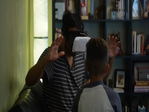 Slow motion of father and son playing with VR headset Stock Footage 78453194