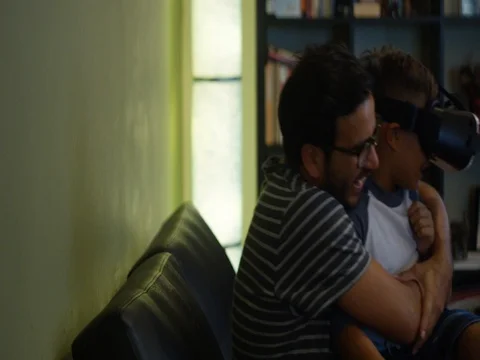 Slow Motion of father holding his son who is Virtual Reality headset Stock Footage 78453581