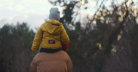 Slow motion: Father put boy on his shoulders and carrying him around suburban Stock Footage 128502623