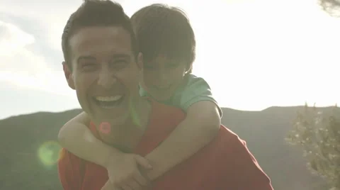 Slow motion of father with son on back playing in countryside. Stock Footage 43670054