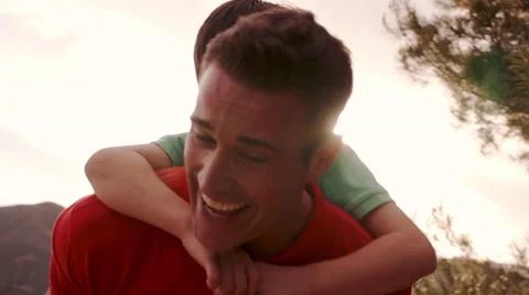 Slow motion of father with son on back playing in countryside. Stock Footage 43670083