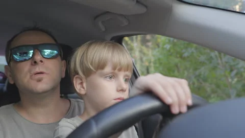 Slow motion. Father teaching his little son to drive a car. Video stock 280599431