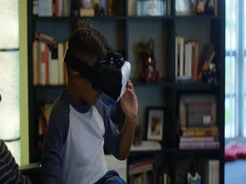 Slow Motion of father watching his son play with Virtual Reality headset Stock Footage 78452625