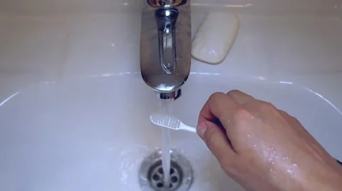 Slow motion of female hands squeeze the toothpaste on the brush to the sink top Stock Footage 53289547