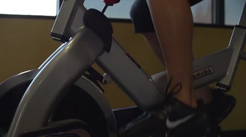 Slow motion of female legs on exercise bike at gym (240fps) Stock Footage 33665252