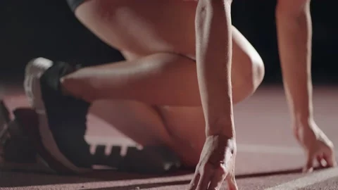 Slow motion female runner at the start close-up in the dark at the stadium Stock Footage 163435862