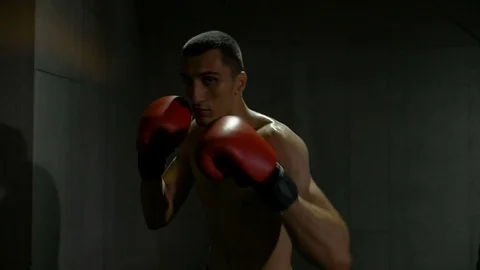 Slow motion of fighter training himself and hitting punches at the sport gym Stock Footage 77795414