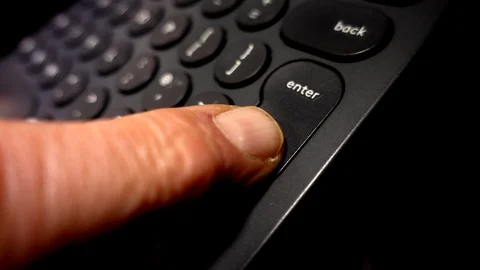 Slow motion: Finger pressing enter key on a computer keyboard. Stock Footage 98736759