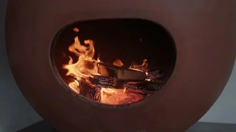 Slow motion of a fire seen through the opening of a brown clay-furnace Stock Footage 167754114