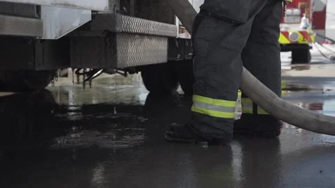 Slow motion firefighter dripping water firehose firetruck fireman Stock Footage 166187189