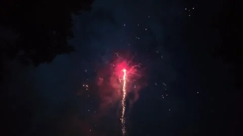 Slow motion of fireworks exploding in the night sky directly overhead while Stockbeeldmateriaal 340115743