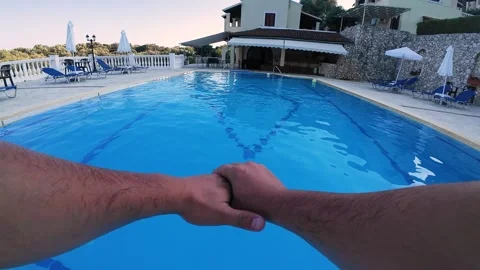 Slow motion first person view of a man diving in a pool and swimming underwater Stock Footage 312523291